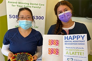 dental staff holding a fruit pie and dental assistant recognition week card