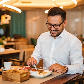 Man smiling while enjoying meal at restaurant
