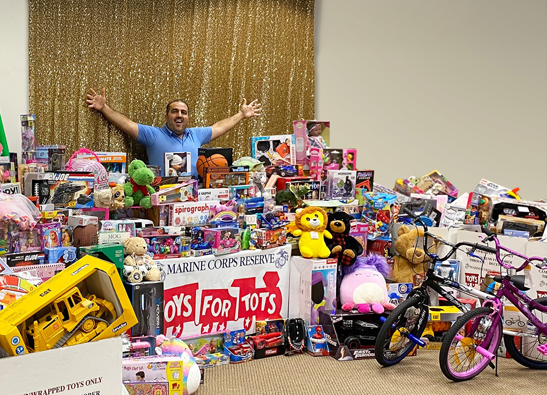 Orthodontist posing with a room full of donated goods