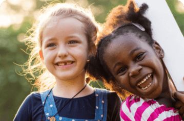 Two young girls grinning in the sun