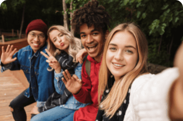 Group selfie of several teenagers sitting on a bench