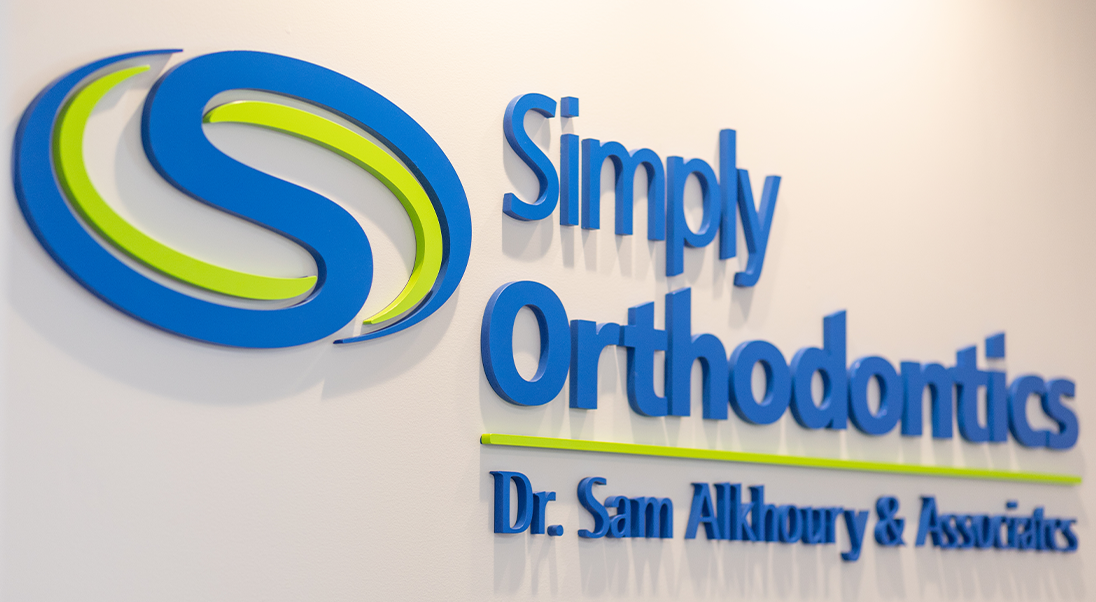 Sign on a wall reading Simply Orthodontics Doctor Sam Alkhoury and Associates