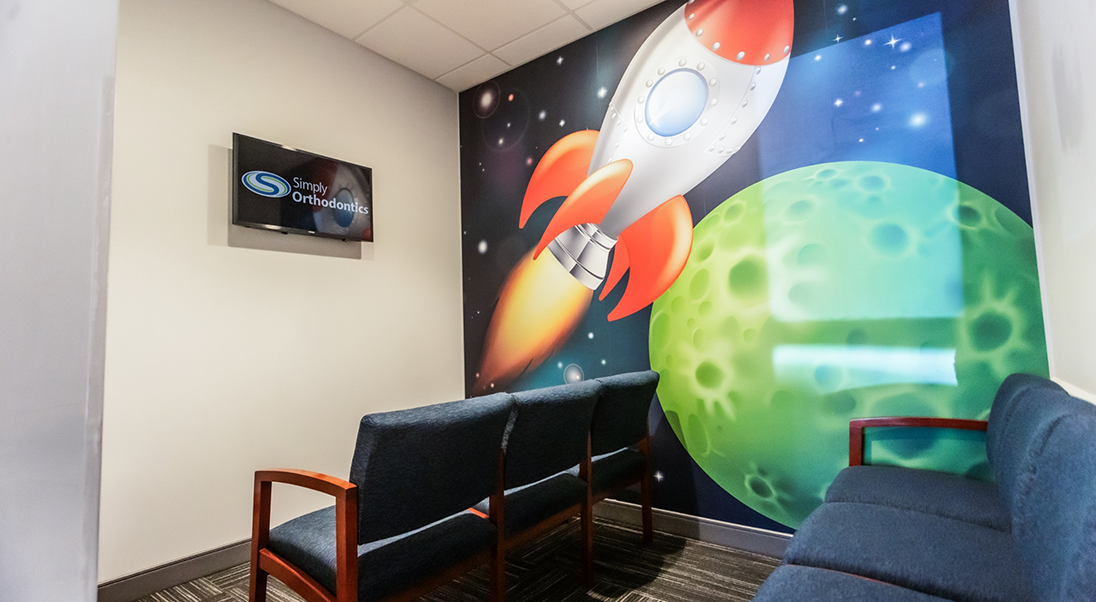 Wall mural showing a green planet and a rocket ship