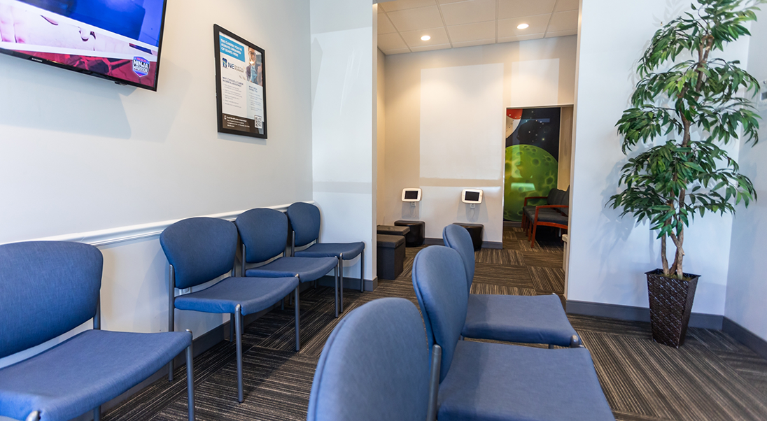 Row of dark blue chairs in the waiting area
