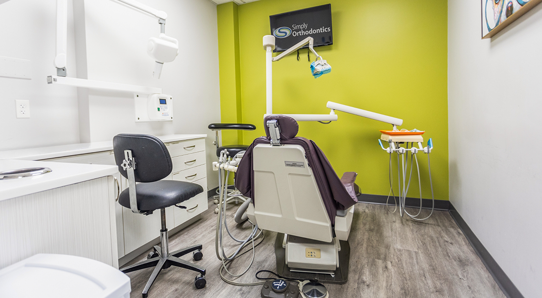 Treatment room with a light green wall and two white walls