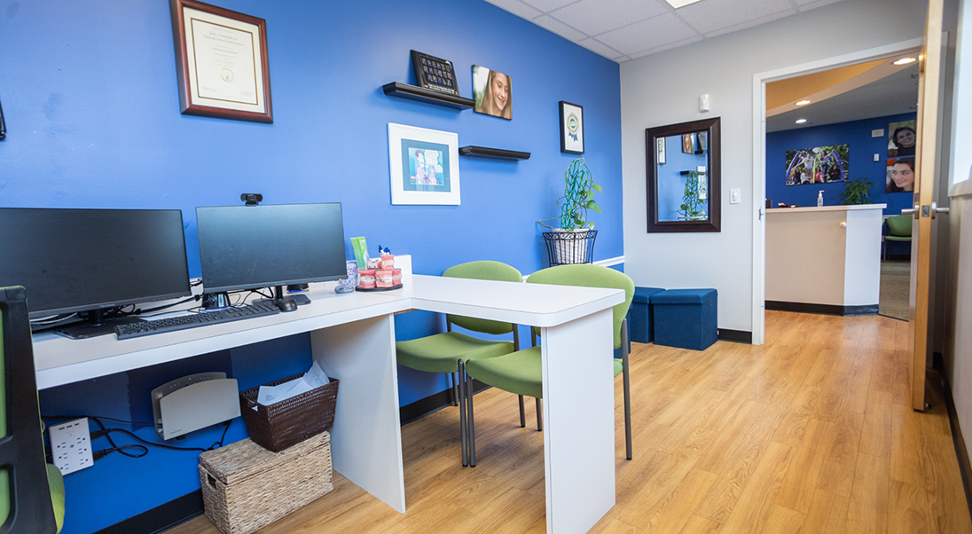 Desk with a computer and chairs in a consultation area