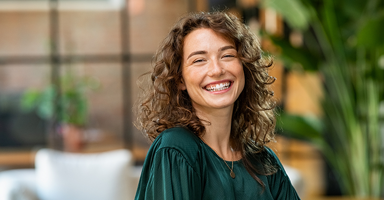 Woman with curly brown hair smiling
