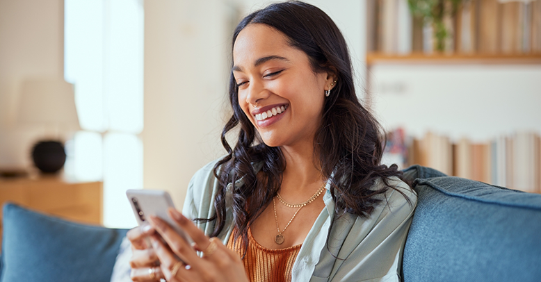 Woman smiling while looking at her phone