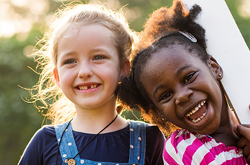 Two young girls smilig in the sun