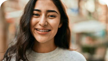 Young woman with braces and long brown hair smiling