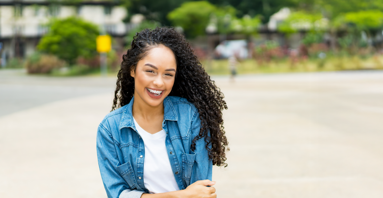 Smiling woman with braces and a denim jacket