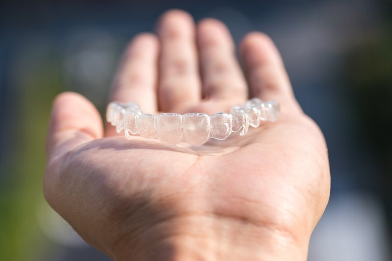 hand holding an Invisalign aligner