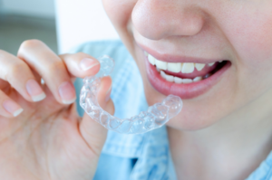a patient holding their Invisalign aligner