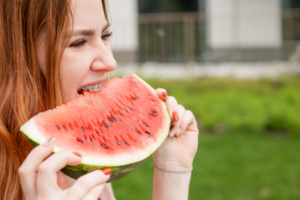 a person with braces eating a watermelon
