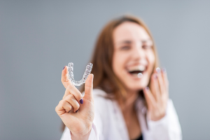 a patient holding her Invisalign tray