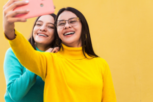 two teens with braces smiling for a photo