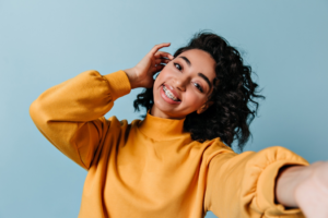 a patient with braces smiling confidently 