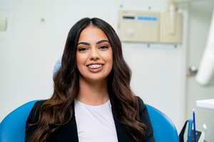 an adult with braces smiling confidently