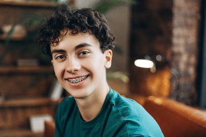 a teen with braces smiling confidently