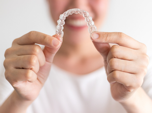 a patient holding an Invisalign tray